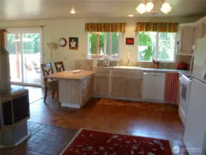 Sunny farmhouse-style kitchen.  Note pellet stove, one of several heating types.