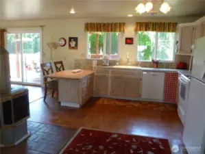Sunny farmhouse-style kitchen.  Note pellet stove, one of several heating types.
