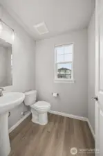 Powder room located on main level with LVP flooring.