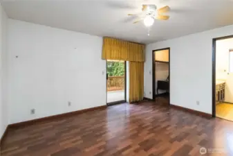 Spacious primary bedroom with private deck access, walk-in closet, and en-suite bath