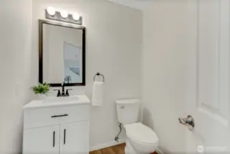 This cute half bath next to the office has a new vanity, new toilet, and of course new paint and flooring!