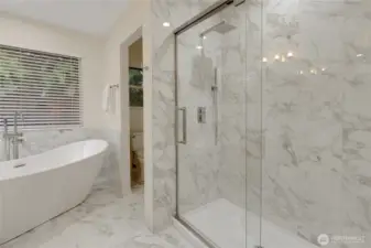 Another angle of the primary bath to include the fabulous new tile shower enclosure with a soft closing pivot door. New toilet in the back room as well. This room also has tall ceilings with a large skylight!