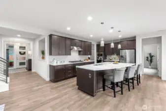 Breathtaking kitchen features large quartz island with prep sink, stainless steel appliances, gas range and plenty of storage.