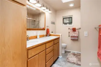 Bathroom has double sinks and ample storage room