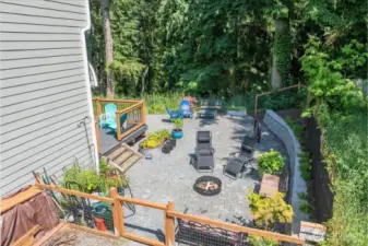 Expansive fenced in backyard with fire pit.