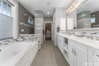 Primary ensuite bathroom with radiant heated floors, double sinks, walk-in shower, and large soaking tub.