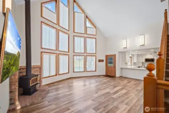 What a beautiful and dramatic room, with two stories of glass windows. Easy care LVP flooring and a cozy wood stove for chilly nights