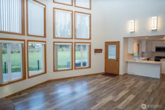 Soaring windows with custom blinds and views to the rear of the property, expansive deck and hot tub.