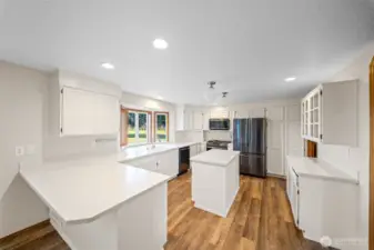 The kitchen cabinets are a crisp white with easy care, solid surface counters. Loads of storage and counter space for informal dining options