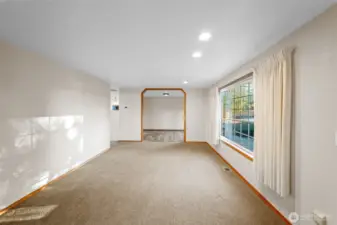 Looking toward the dining room, the living room at the front of the house provides a second living space at the front of the house. Striking arched doorways and warm wood trim and paint. Everything is sparkling clean!