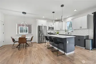 Down the hall in the back of your home is your open concept kitchen and family room. This one-owner home features many upgrades including these light fixtures! Granite countertops, full-tile backsplash and your walk-in pantry is on your left.
