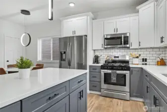 Kitchen view to dining, you will love the quiet close doors & drawers and the 5-burner propane gas stove. Large island for entertaining!