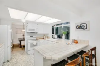kitchen opening to casual dining area & den w/ backyard access