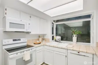 kitchen opening to casual dining area & den w/ backyard access