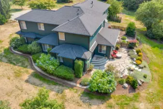 From this aerial perspective, the sophistication and scale of the home are immediately evident. Nestled gracefully on 5.74 acres, the property showcases its elegant architecture, landscaped grounds, and surrounding open space. The winding driveway, stone patio, and sprawling outdoor areas are all highlighted in the following photos, offering a comprehensive view of both the home’s beauty and the serenity of its private setting.