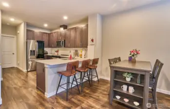 Dining area with large kitchen, stainless steel appliances and quartz counter tops.