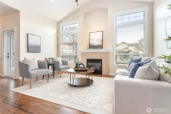 Abundant light welcomes you into this vaulted living room with extra tall windows, cozy gas fireplace & alcove