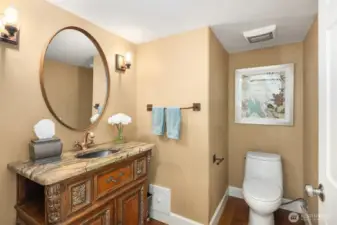 Located on the main level is a powder room for guests, featuring a custom-made vanity that contributes to the luxurious feel of the home.