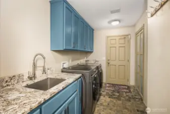 This home boasts a spacious laundry room with luxury upgrades. One of the nicest features is the high-end slab stone countertops, ideal for folding clothes or serving as a workspace.