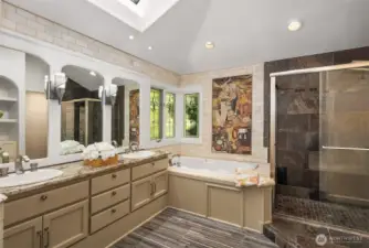 Indulge in spa-like luxury with this elegant primary bathroom featuring dual vanities, a soaking tub, custom stained glass, and a one-of-a-kind mosaic inspired by Gustav Klimt’s The Kiss.