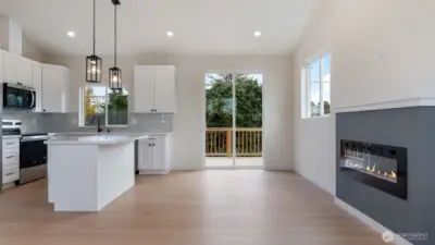 Great Room opens to kitchen and has cozy fireplace and vaulted ceilings.