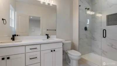 Primary Bath has large vanity, dual undermount sinks, tile flooring and floor to ceiling tiled shower.
