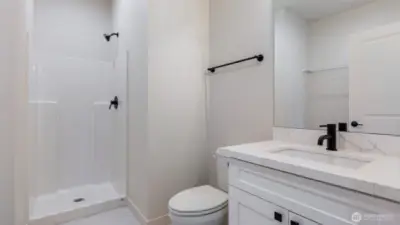 Three Quarter Bath/Laundry Room offers tile flooring, Vanity with quartz counter and undermount sink.