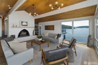 A dramatic arched fireplace anchors the elegant living room, complemented by warm wood ceilings and sweeping views across Cayou Channel.