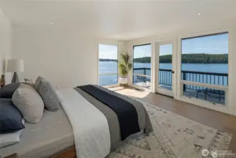 Wake up to panoramic water views from this beautifully appointed primary suite, complete with floor-to-ceiling windows and direct access to the waterfront deck. Thoughtful minimalist styling highlights the breathtaking scenery as the focal point.