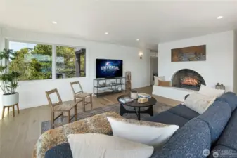 This beautifully remodeled living room features floor-to-ceiling windows framing sweeping Cayou Channel views, complemented by a cozy wood-burning fireplace and designer coastal finishes. A bright, open layout enhances natural light and creates an inviting space for year-round island living.
