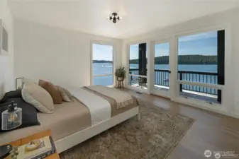 This stunning bedroom is surrounded by oversized windows that frame sweeping water vistas toward Blind Bay. Natural light fills the space, complementing the home’s warm, modern design aesthetic.