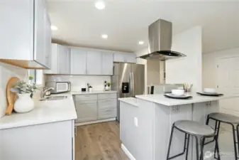 Gorgeous remodeled kitchen with luxury finishes: shaker cabinets, quartz counters, subway tile, stainless appliances and eating bar. Lots of counterspace!