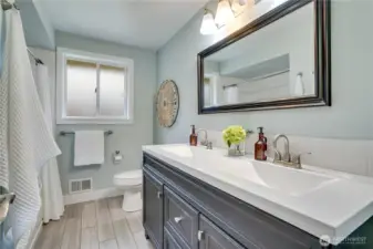 Full bathroom with dual vanities located across the hall from the primary bedroom