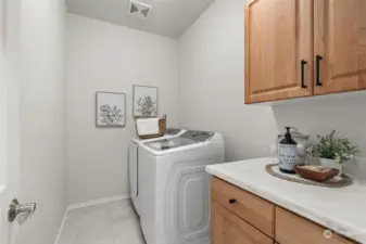 Laundry room with updated counters as well on main level, across from powder bathroom next to kitchen.