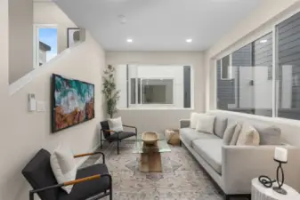 This light-filled living room is the perfect spot to kick back and relax! Thoughtfully designed with oversized windows, clean, modern finishes, and a cozy yet stylish ambiance, it's a space that feels like home.