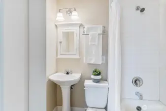 Functional bathroom with full tub, white tile walls, and modern touches that keep the historic charm intact.
