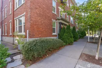 Corner condo in a boutique, character-filled building surrounded by leafy tree-lined sidewalks.