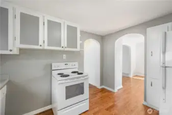 The kitchen also offers matching white appliances and continued arched doorways.