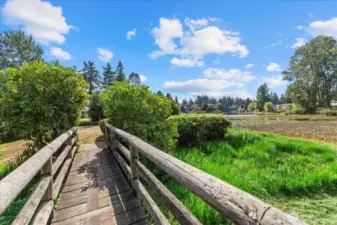 Footbridge to grassy area & picnic table overlooking the lake.