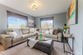 As you arrive upstairs, the bonus room welcomes you as a cozy TV lounge—perfect for movie nights, game days, or relaxed downtime with family and friends