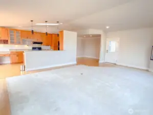 Looking from the corner of the living room back to the kitchen, formal dining area and front door.