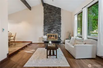 Formal living room has custom stone fireplace.