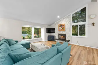 A striking tile fireplace surround anchors the living area, while high vaulted ceilings amplify the openness of the great room.