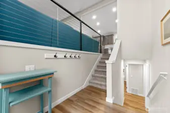 A welcoming entry showcases modern custom cable railing and durable LVP flooring.