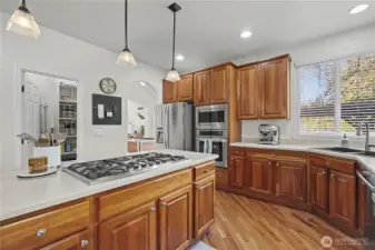 View one of your chef's kitchen - facing the formal dining room. 5-burne gas cooktop on the island invites family and friends to join in the cooking. Walk-in pantry straight ahead to your left. I love all the Corian countertops and gorgeous cabintry and flooring.