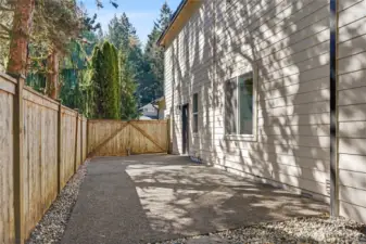 View of the right side of the backyard showing the paved RV/Boat parking area.