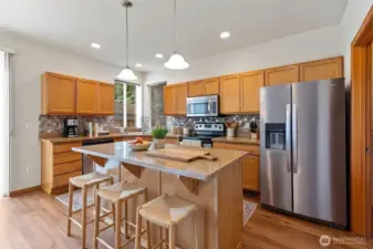 Virtually staged Kitchen. Stainless appliances - Range, microwave and refrigerator stay with house. Walk in pantry on right of picture