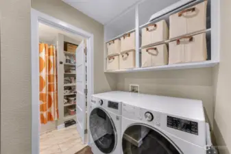 Full-sized washer and dryer and built-in shelving.