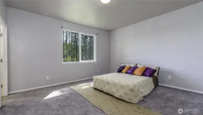 Space primary bedroom with a walk in closet and attached bathroom.
