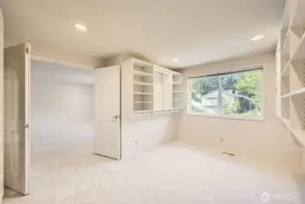 The Primary Suite’s walk-in closet is as large as a normal bedroom and it has many built-in shelves, a large window and a double-door entry.